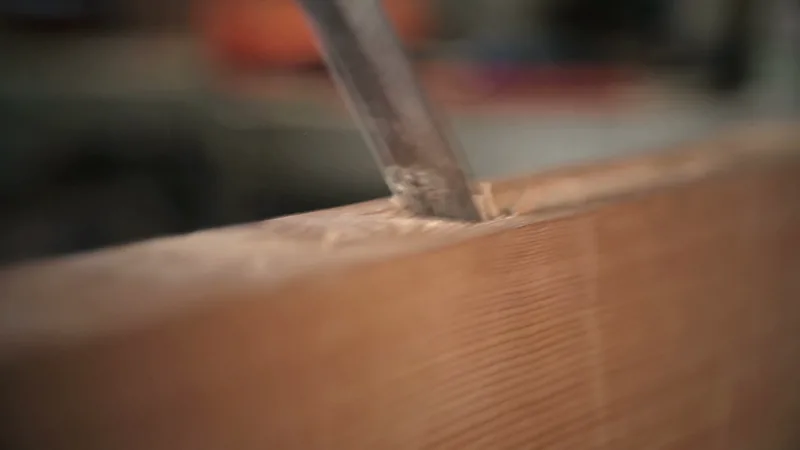 Ciseau à bois entaillant une pièce de bois dans l'atelier d'Ebenbee