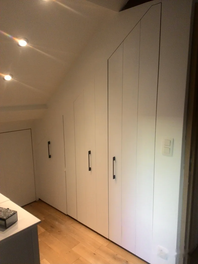 Garde-robe sur mesure sous pente, portes blanches à poignées noires