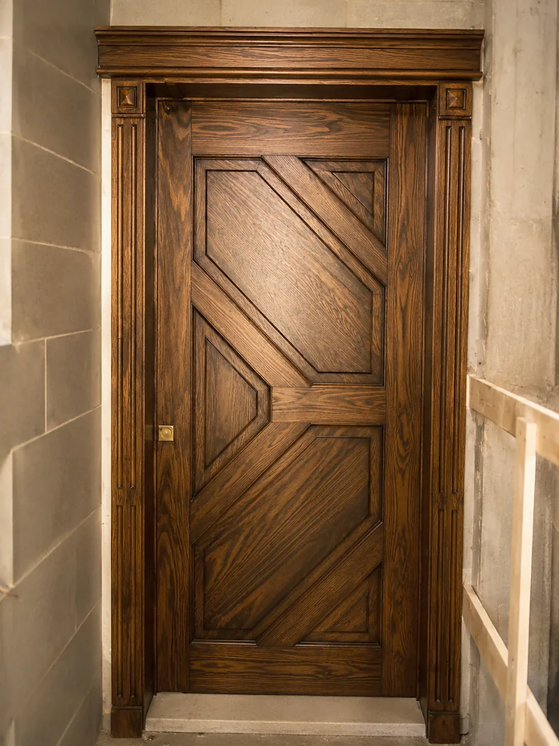 Porte en bois à panneaux en chevrons, avec encadrement mouluré